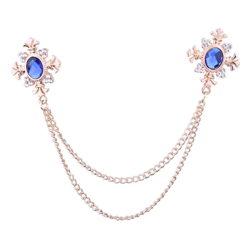 Crystal cross chain brooch with double layered chain design on white background.