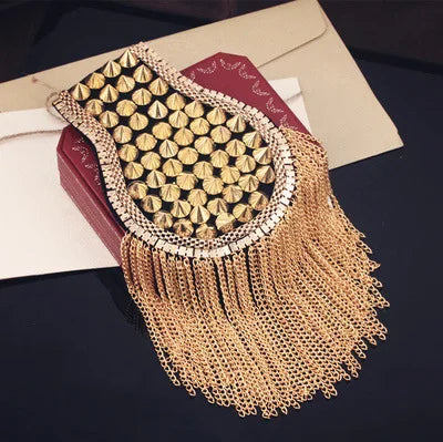 Gold studded tassel fashion accessory on dark surface