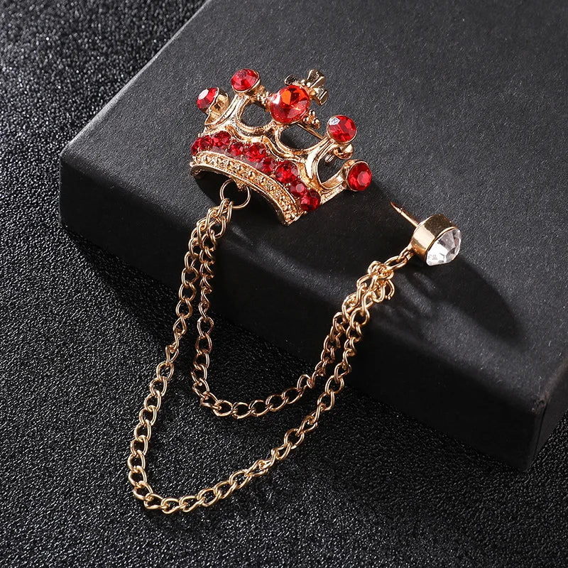 Decorative brooch with red gemstones and gold chain on a black background