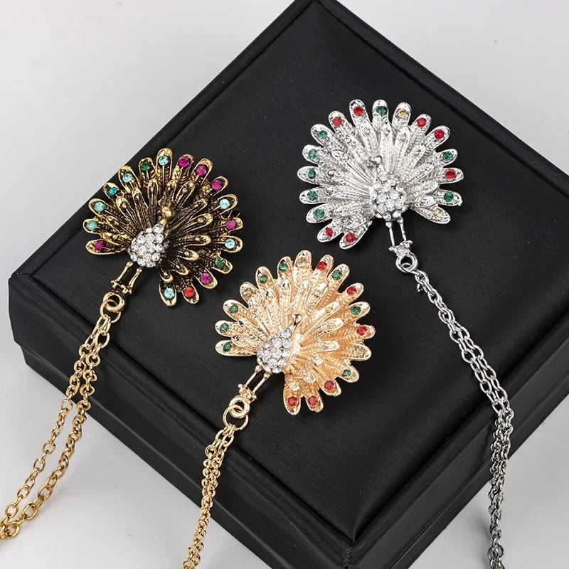 Three decorative brooches with chains luxury fashion accessory collection on black box