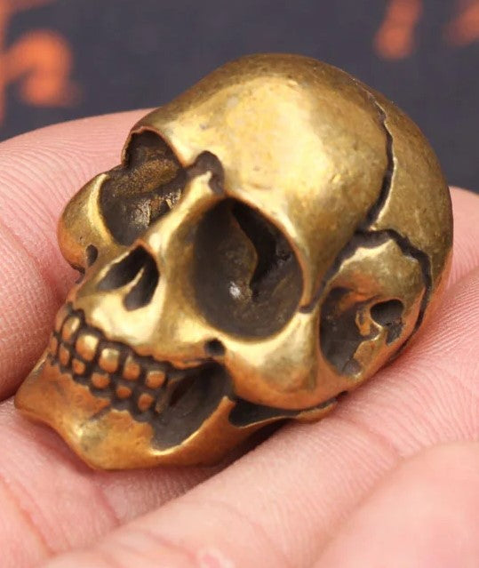 Solid brass skull head figurine with antique finish for gothic home decor, office desk decoration, and collectible display on show on hand