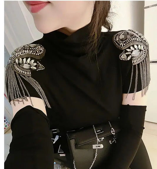 Black outfit with decorative tassel shoulder brooch and handbag accessory