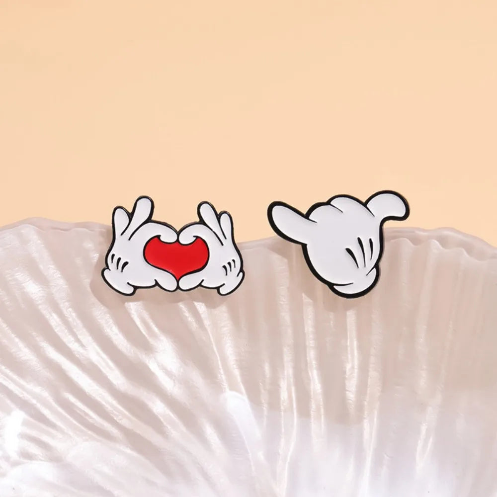 Cute love hand gesture pin with red heart on beige background