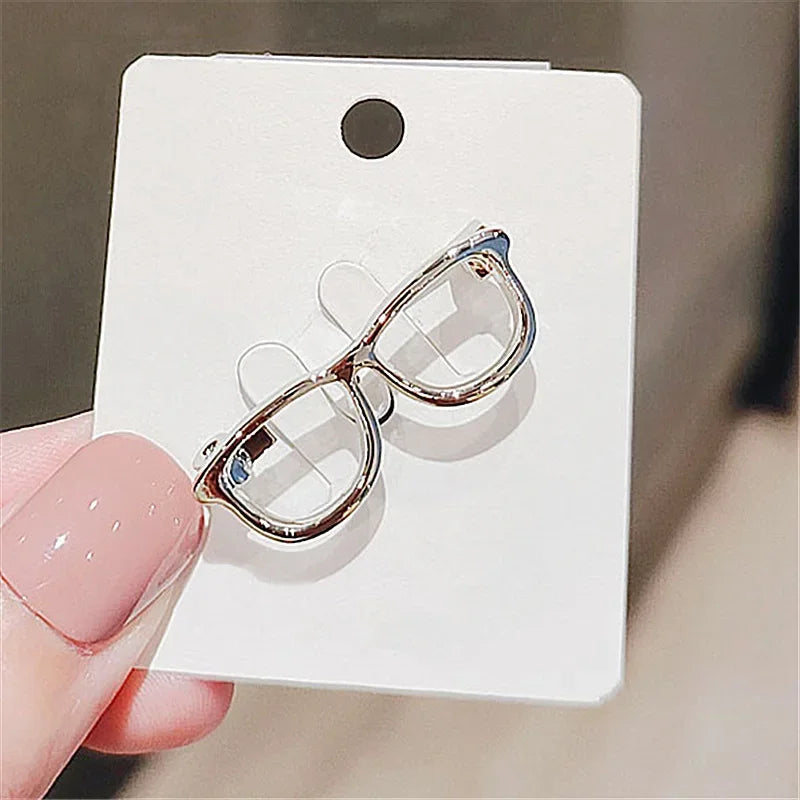 Small eyeglasses lapel pin displayed on white card background