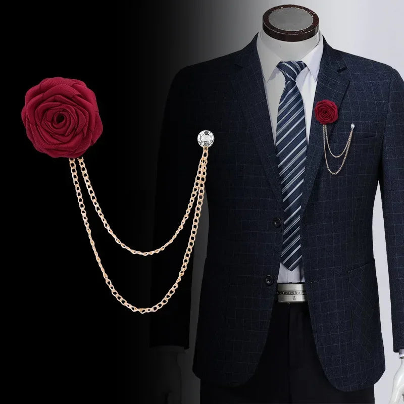 Mannequin wearing a formal suit styled with a floral lapel brooch and decorative chain accessory.