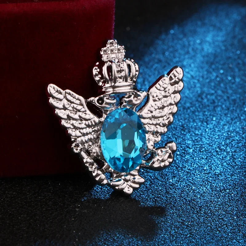 silver angel brooch with sky gemstone luxury fashion jewelry on blue and red fabric background