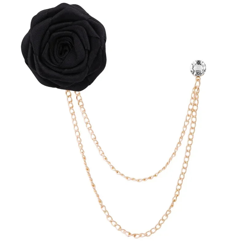 Black rose flower brooch with gold chain and crystal on a white background