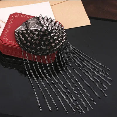 Studded fashion brooch with metallic fringe chain detailing
