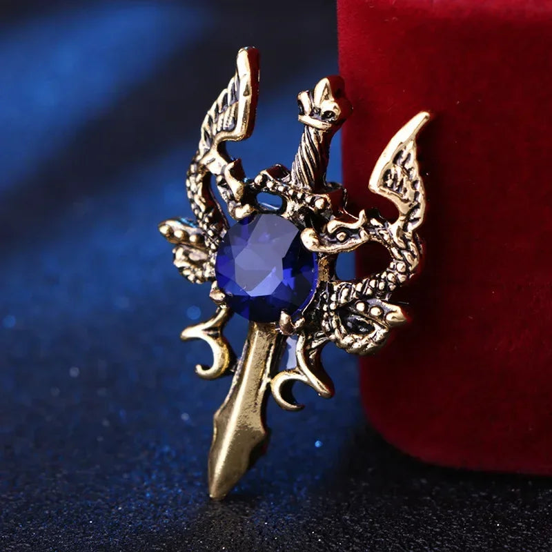 Gold decorative brooch with blue gemstone luxury fashion jewelry pin on red fabric