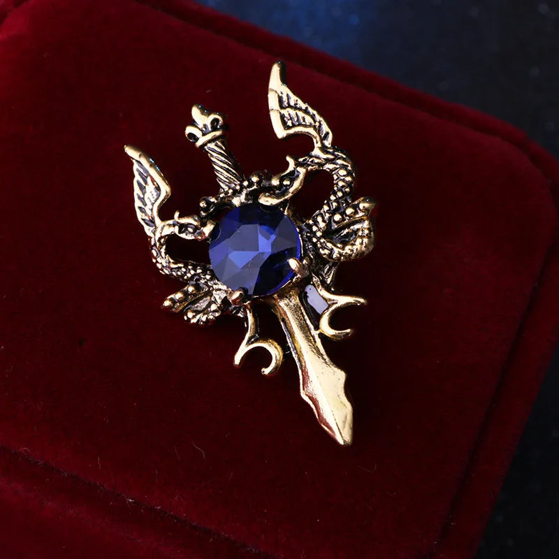 Gold decorative brooch with blue gemstone luxury fashion jewelry pin on red fabric