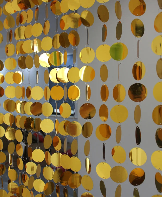 Gold circular disc sequin curtain on a gray background