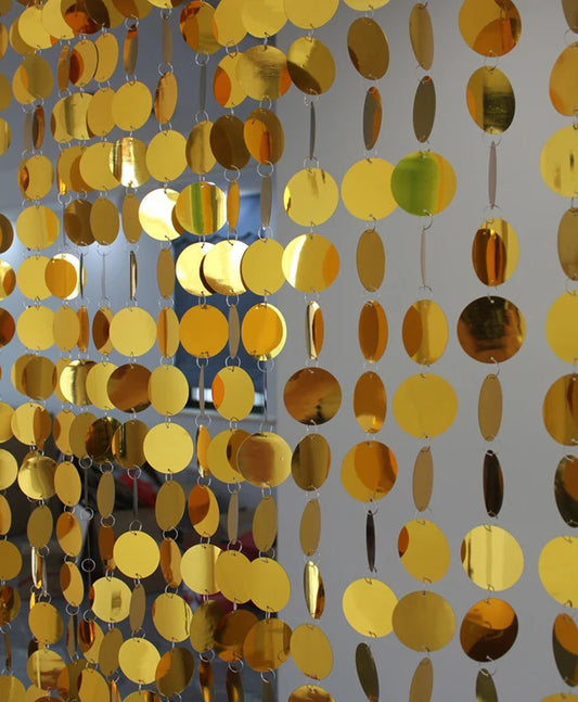 Gold circular disc sequin curtain on a gray background