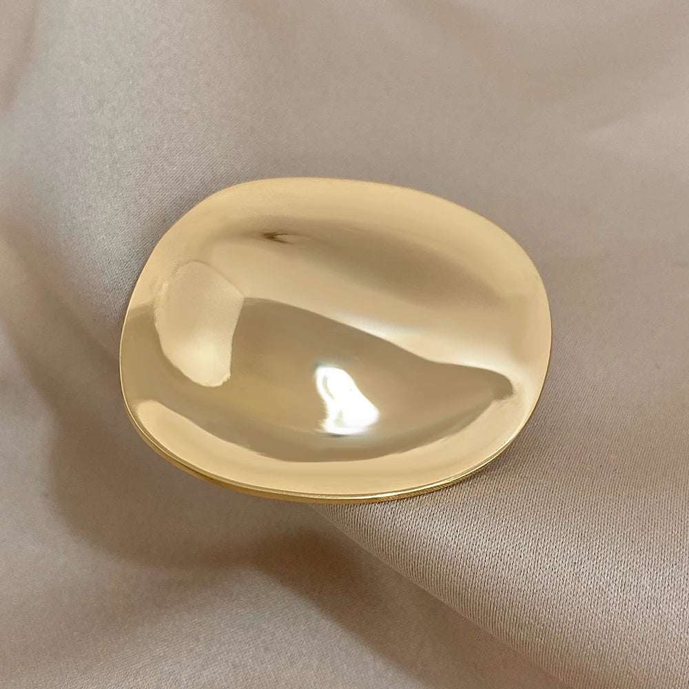 Gold decorative brooch on a beige fabric background