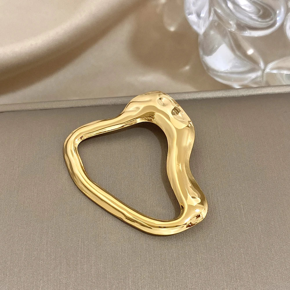 Gold Abstract shape on a beige surface with a blurred background