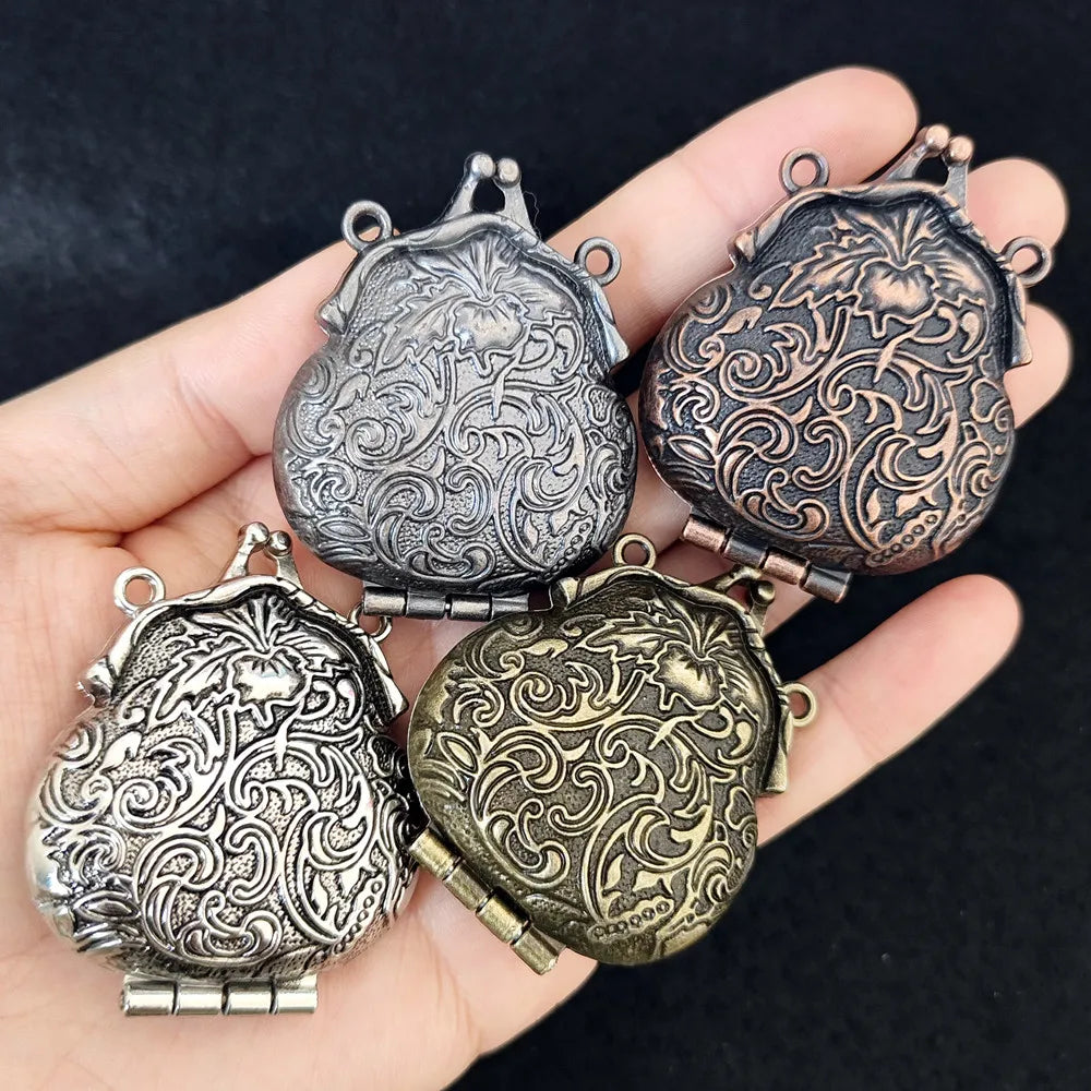 Four ornate metal pouches in different colors held in a hand against a dark background.