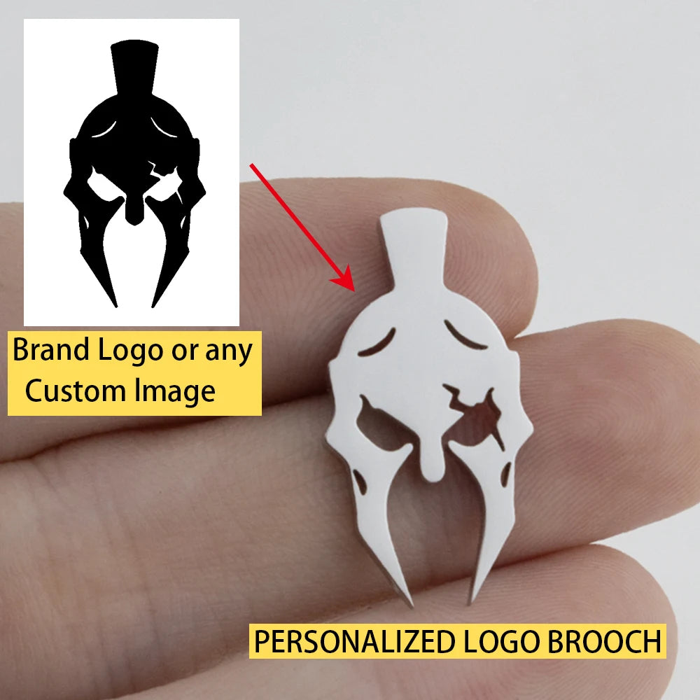 Personalized logo brooch held between fingers with brand logo inset