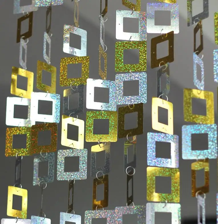 Decorative sequin string with square-shaped metallic sequin on a dark background