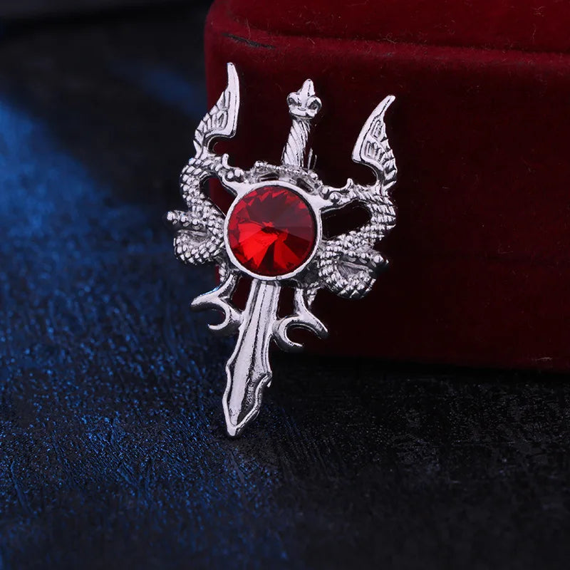 Decorative brooch with red gem and silver accents on a dark background