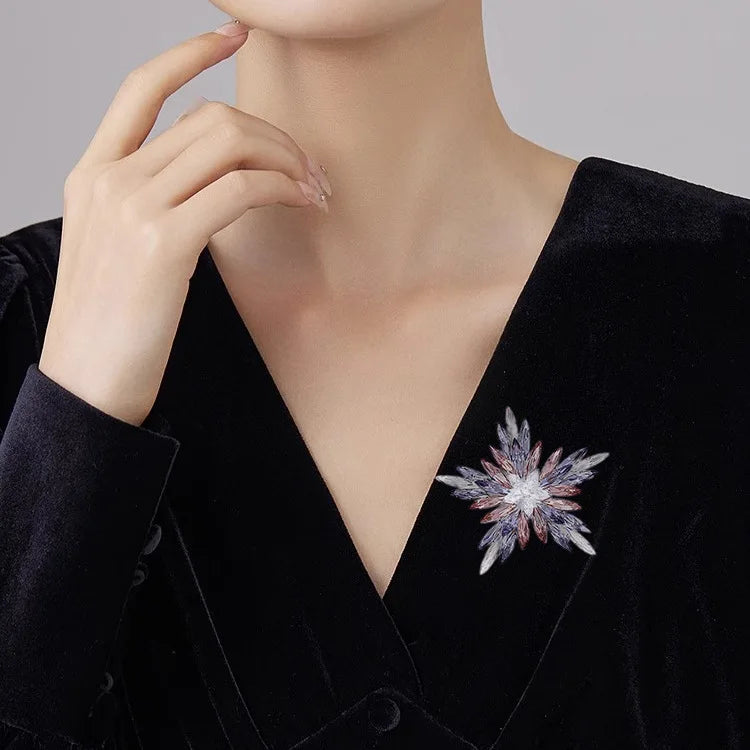Woman wearing black blazer with sparkling crystal snowflake brooch accessory