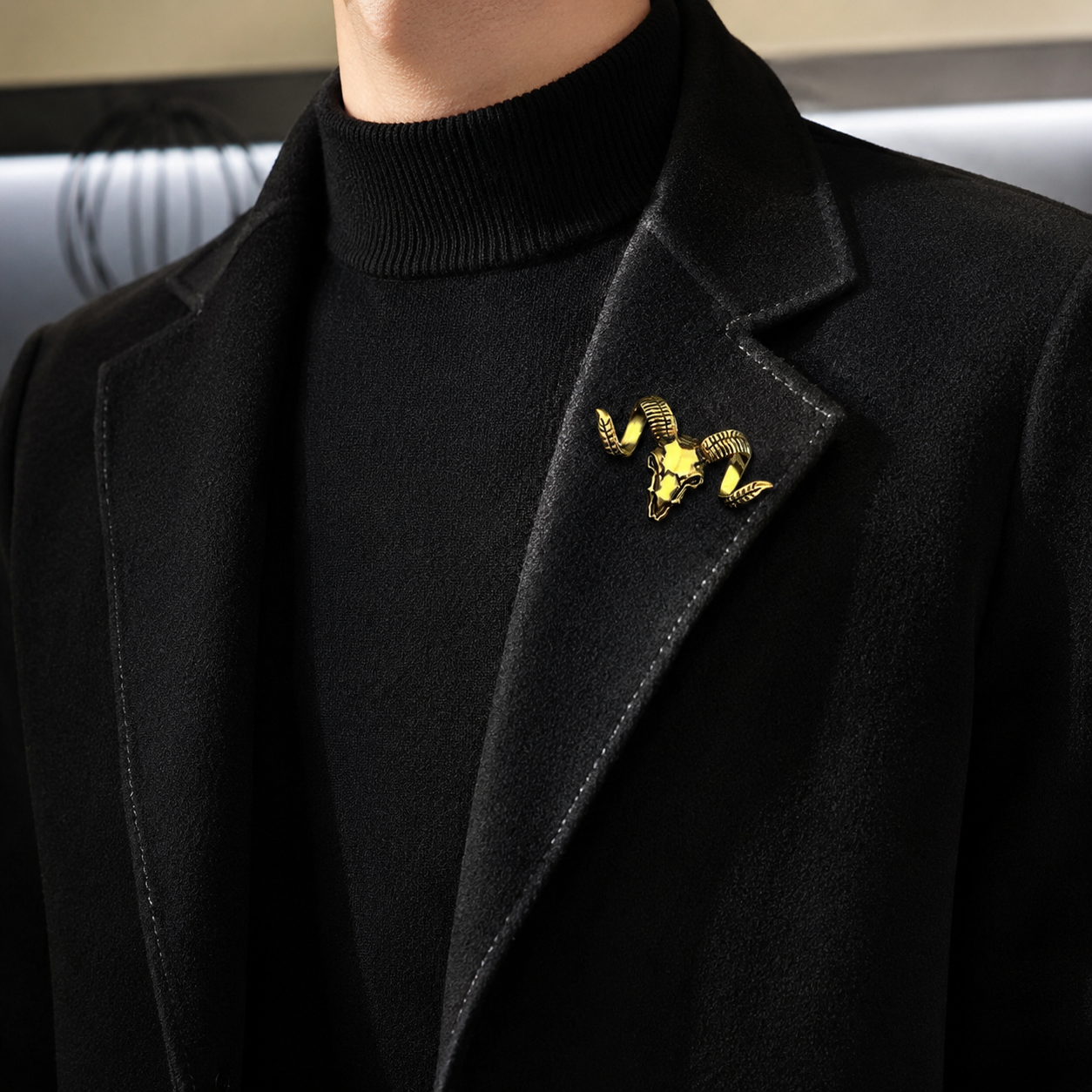 Fashion model wearing a black coat with a ram skull lapel brooch.