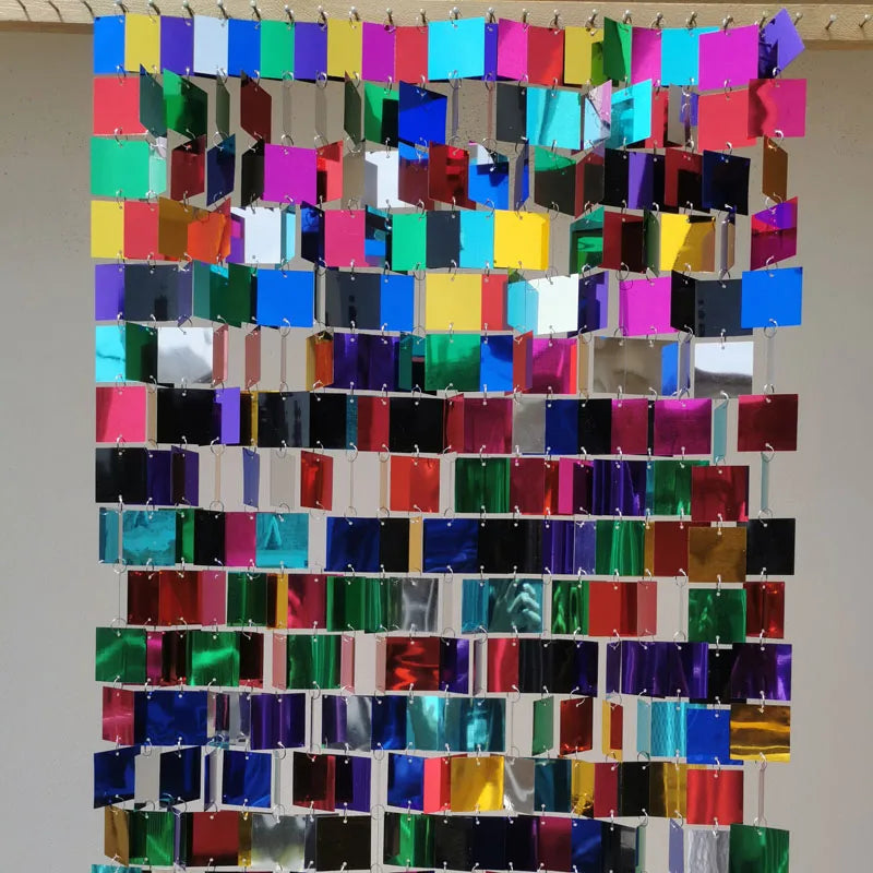 Colorful grid of square sequin  panels on a plain background