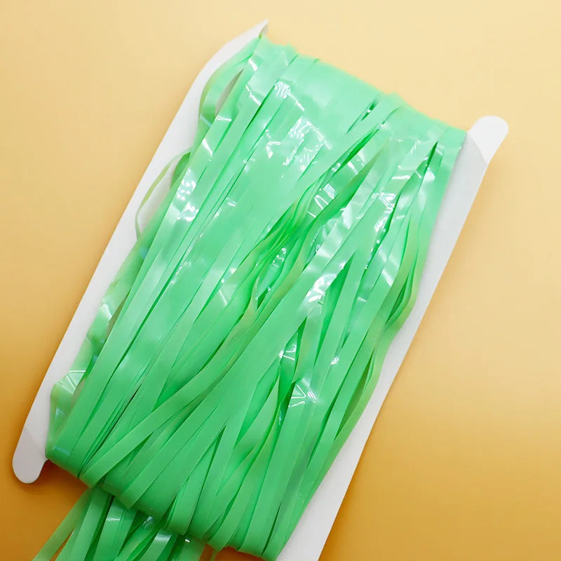 Green ribbons on a white tray against a yellow background