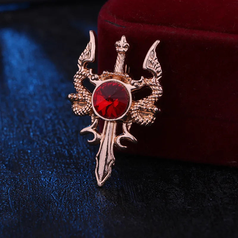 Decorative brooch with red gem and gold accents on a dark background