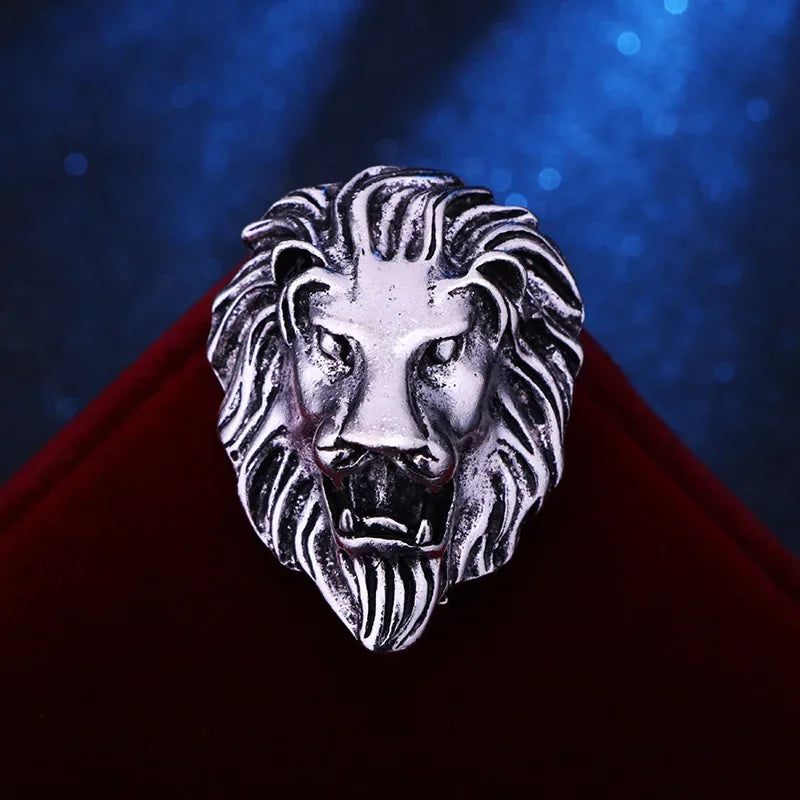 Silver lion head ring on a red surface with a blue gradient background