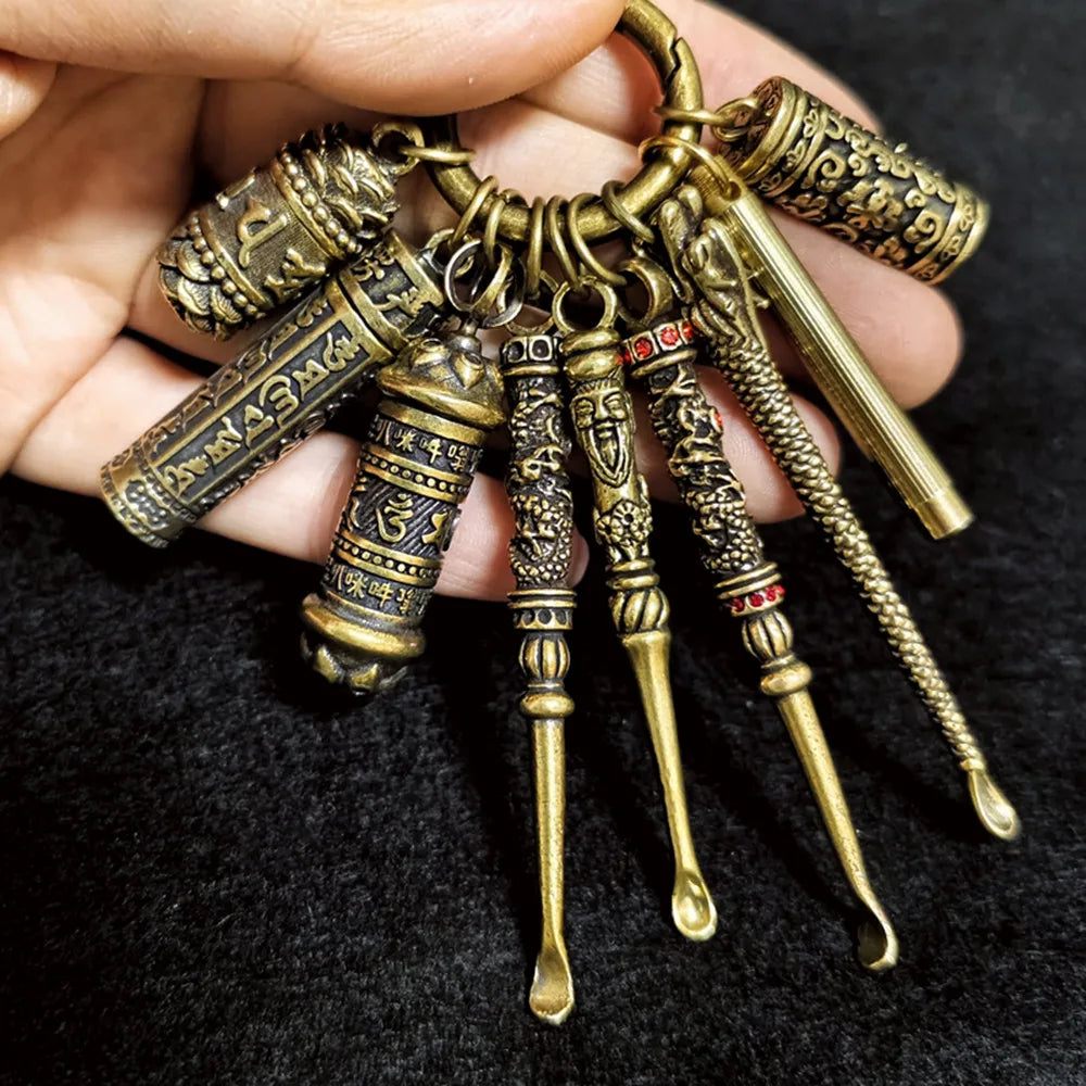 Hand holding assorted retro brass keychains with antique finish