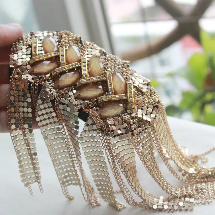 Premium rhinestone shoulder epaulette brooch with crystal accents held in hand.