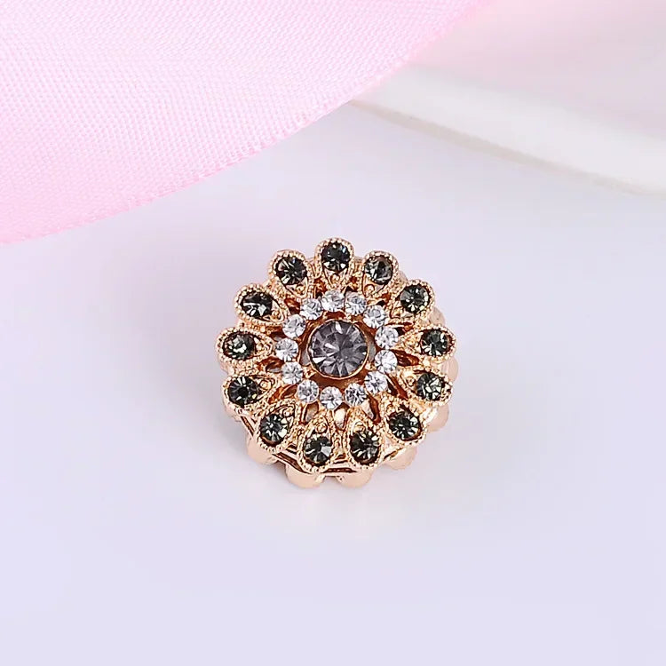 Elegant magnetic flower brooch set with multicolor gemstones on a light pink background
