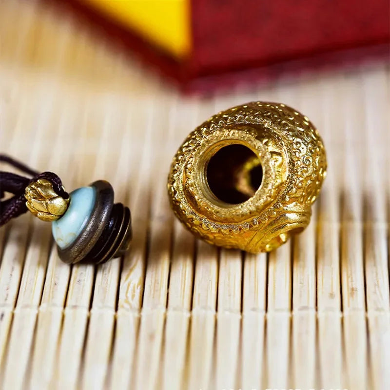 Close-up of antique conch shell pendant highlighting storage opening and premium metal craftsmanship