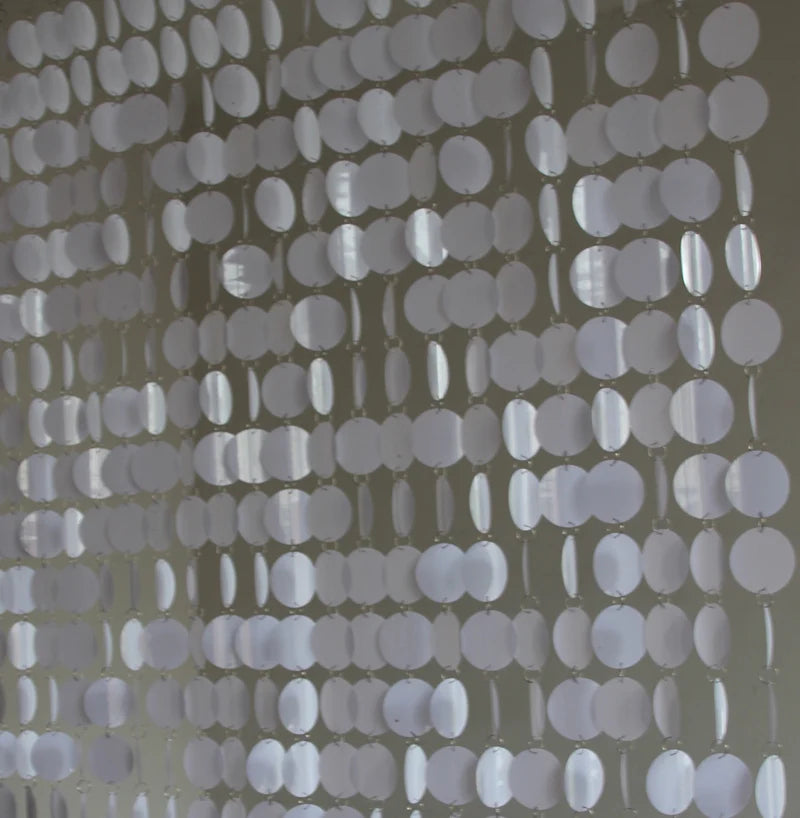 String sequin curtain with circular cutouts on a neutral background