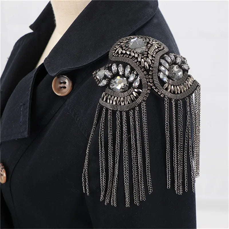 Decorative shoulder brooch with metallic chains on black jacket