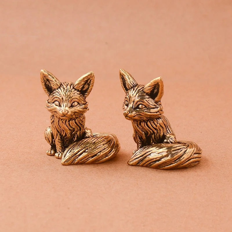 Bronze fox figurines on a brown background