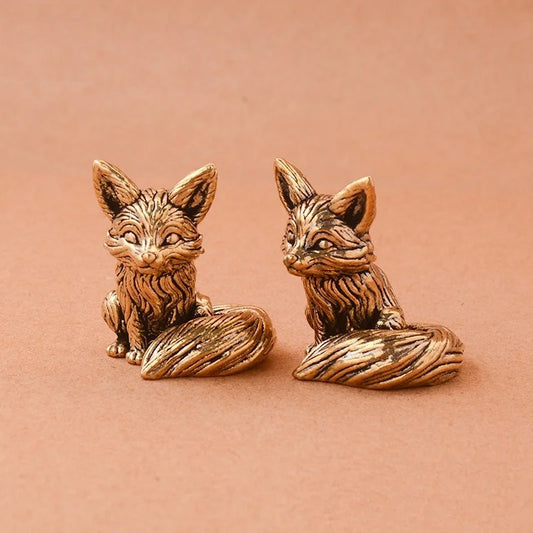 Bronze fox figurines on a brown background
