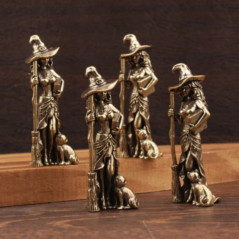 Bronze figurines of witches with brooms and cats on a wooden base.