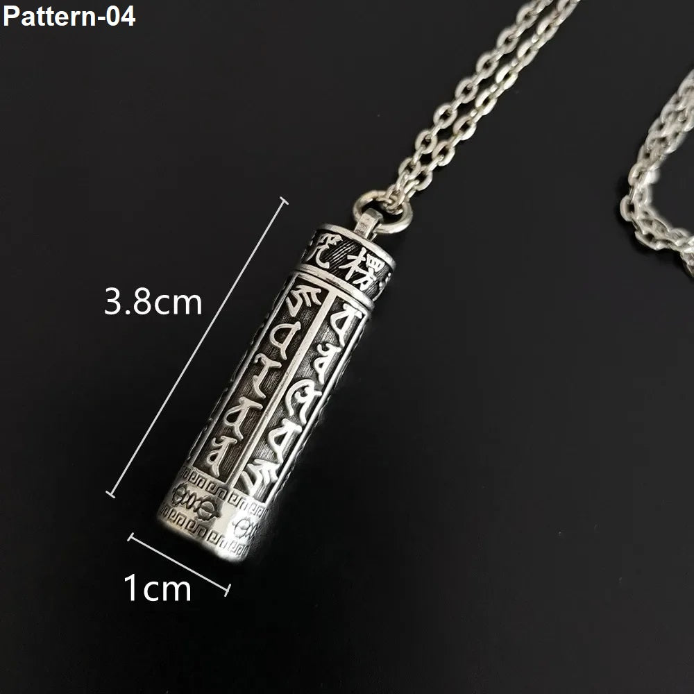 Silver pendant with intricate designs on a black background, showing measurements.