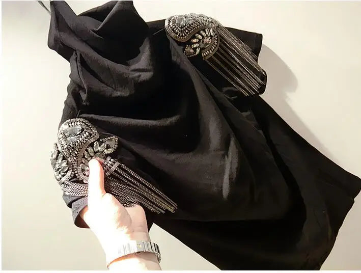 Black fabric accessory with silver embellishment and chain tassels