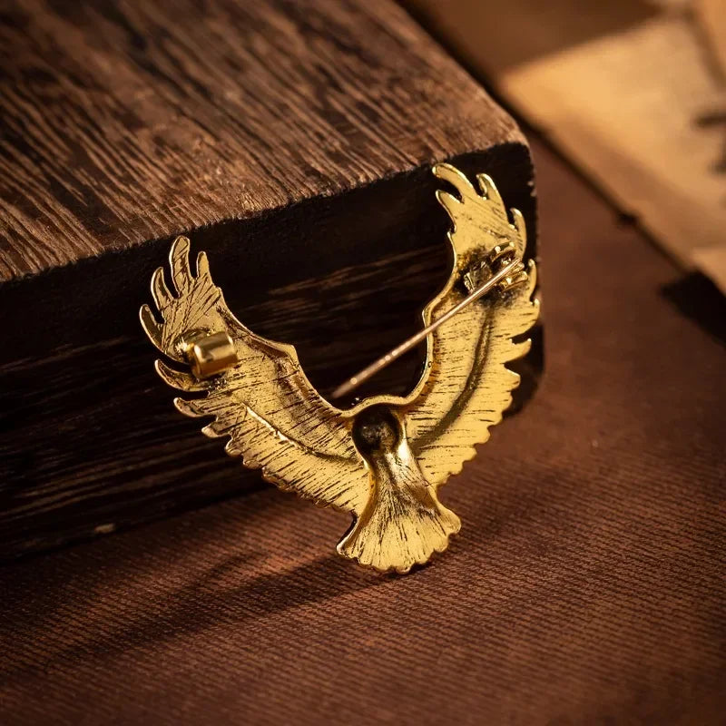 Luxury gold eagle brooch on wooden background