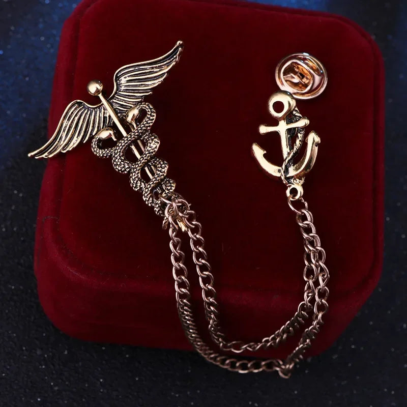 Two gold brooches with chain designs on a red velvet background