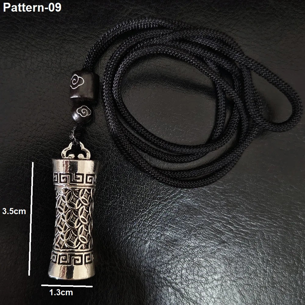 Silver pendant on a black cord with measurements on a dark background