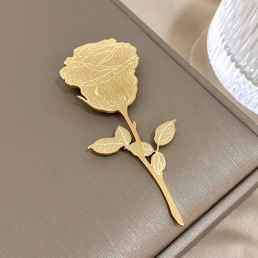 Gold rose-shaped brooch on a textured surface