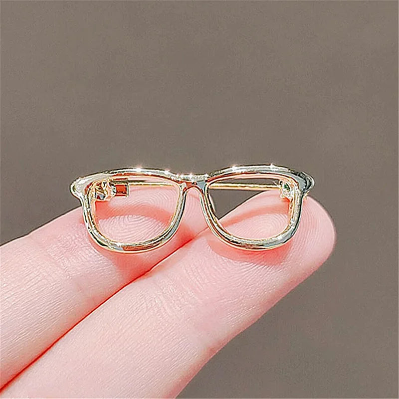 Gold eyeglasses brooch pin close up on neutral background