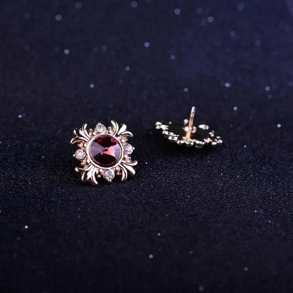 Gold brooch with red gemstones on a dark background