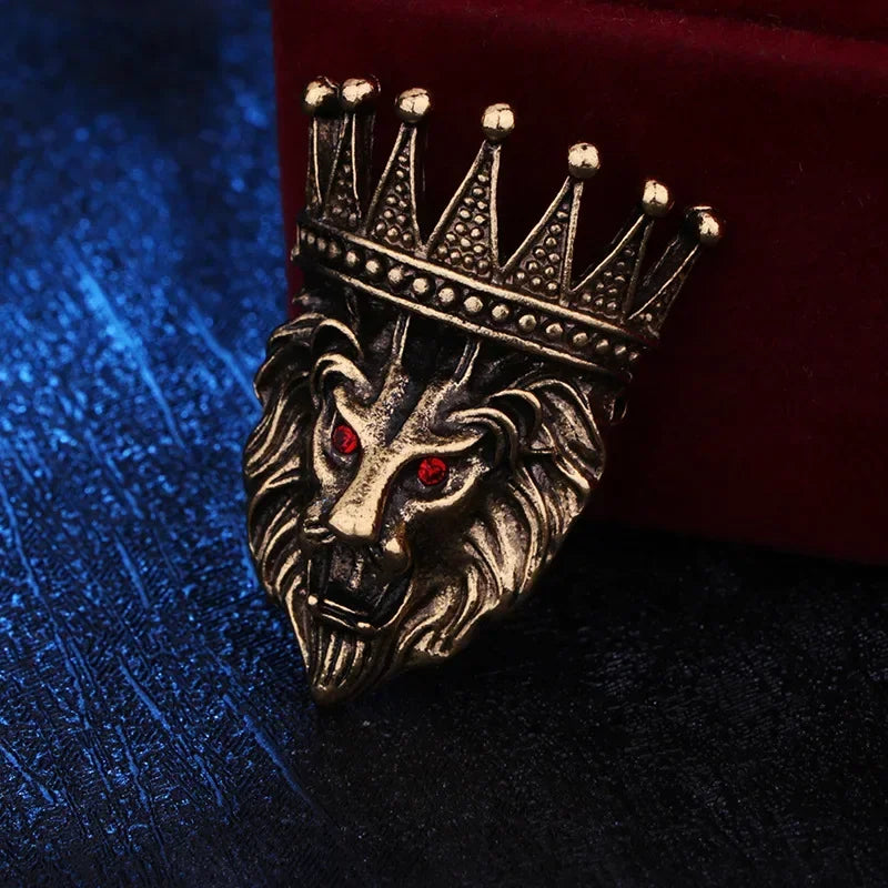 Decorative lion head brooch with crown on textured fabric background