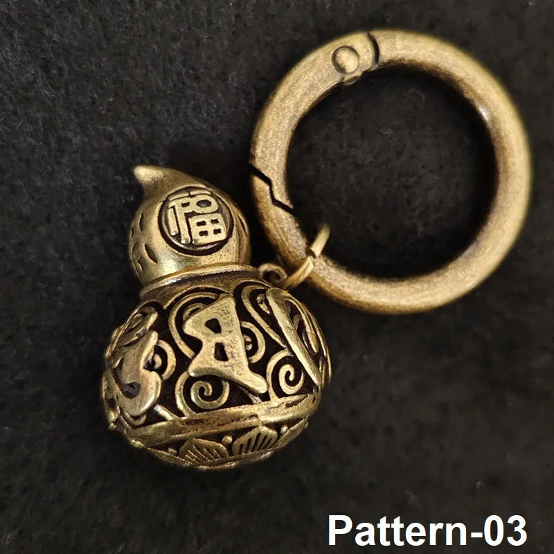 Decorative brass gourd keychain with antique finish on black background