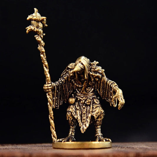 Vintage brass sorcerer bird figurine displayed on a dark background