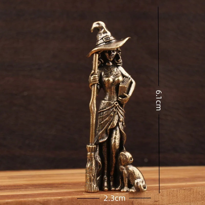 Bronze figurine of a witch with a broom and dog, shown with measurements on a wooden surface.