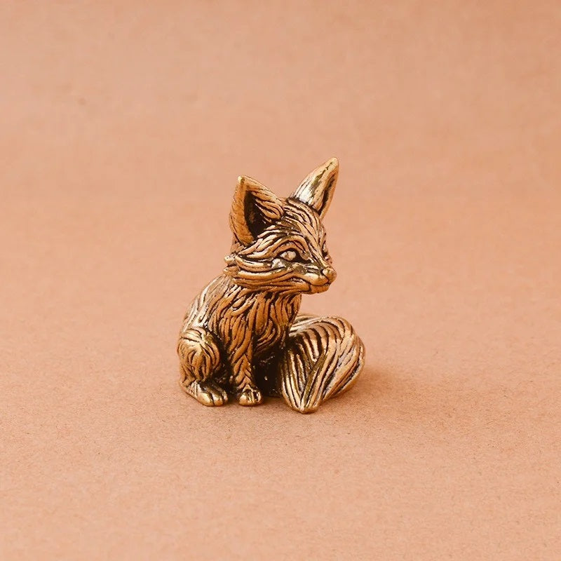 Bronze fox figurine on a beige background
